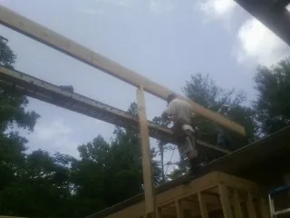 Carpenter setting a ridge beam over a new addition frame — Ice Dam Removal by Roofing Brothers in Horicon
