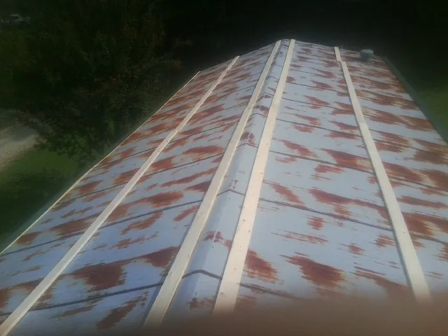 Rusted metal roof panels with new wood purlins before replacement — Storm Damage Roof Repair in Horicon by Roofing Brothers