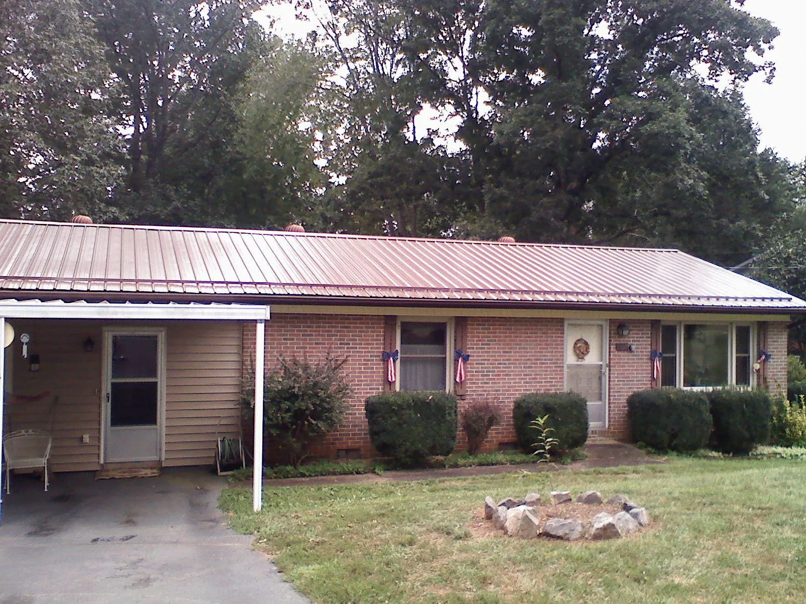 Bronze metal roof and carport on a brick ranch home — Roof Repair work by our crew in Horicon